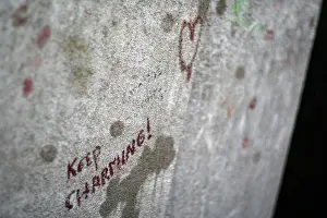 Lipstick Prints: Close-up of the “Keep Charming!” graffiti message on Oscar Wilde's tomb in Père-Lachaise Cemetery