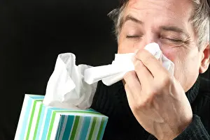 Fever Prints: Close-up of a man blowing his nose while holding a tissue box
