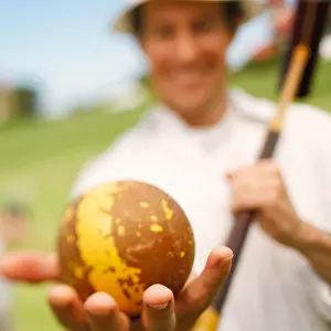 Weekend Activities Prints: Close-up of a mid adult man holding a ball and a croquet mallet