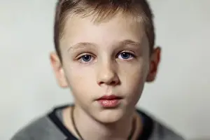 Blue Hair Prints: close-up portrait of serious caucasian boy with freckles in casual wear