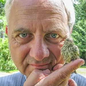 Alertness Prints: Close-up portrait of a man holding a Sparrow on his finger, British Columbia, Canada