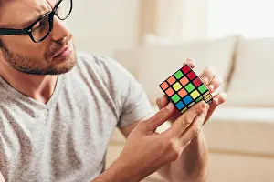 Homey Prints: Close-up portrait of serious young man in eyeglasses holding rubik cube