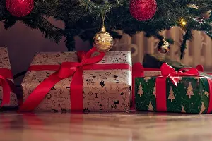 Presents Prints: Close-up of presents spread over the floor under the christmas tree on a beautiful holiday at home