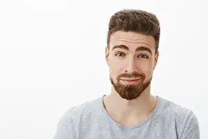 Bristle Prints: Close-up shot of charming kind and charismatic happy bearded man with moustache raising eyebrows