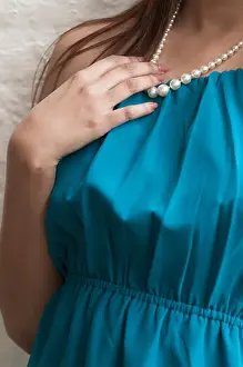 Jewellery Prints: Close up of a young woman wearing a blue dress and pearl necklace