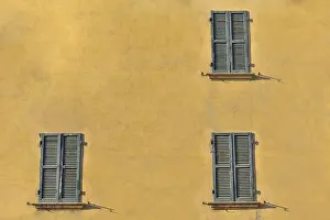 Closed green windows on yellow wall of old house in Florence city, Italy