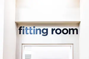 Rooms Prints: Closeup of Fitting Room sign in mall store shop retail clothing changing door entrance with nobody on wall