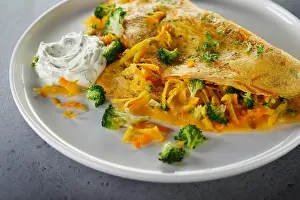 Roast Prints: Closeup fried omelette with broccoli and cheese placed near sauce on plate during lunch