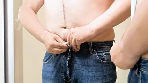 Tight Prints: Closeup photo of shirtless fat man wearing tight jeans at mirror