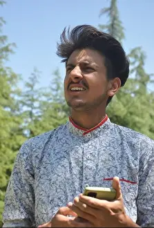 South Asian Prints: Closeup portrait of a Indian good looking young guy standing outdoor in nature