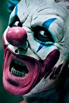 Panic Prints: closeup of a scary evil clown with his mouth open showing his rotten teeth staring at the observer