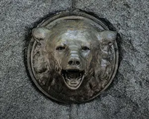 Uneven Prints: a closeup of a sculpture of a bear head with an open mouth on the wall