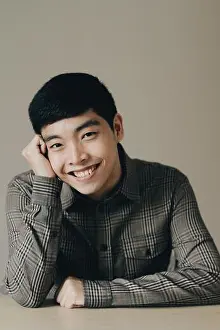 Chin Prints: Closeup vertical portrait of a cute happy Asian man leaning his head into his hand