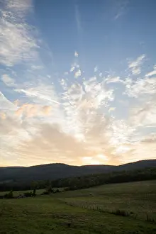 Cumulus Prints: The clouds are backlit by the sun as it rises on a summer morning