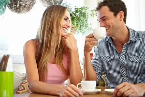Coffee shop conversation. An attractive young couple enjoying a cup of coffee in restaurant