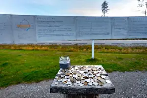 Polar Circle Prints: Coins from different countries left by tourists as a token of memory near the Arctic Circle Board in Overkalix