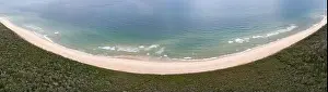 The cold, nutrient-filled water of the Atlantic Ocean washes onto a scenic and empty beach in Eastham, Cape Cod, Massachusetts