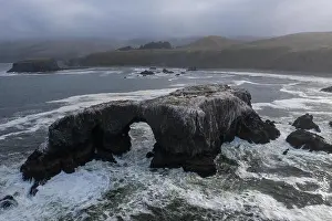 The cold, nutrient-rich waters of the Pacific Ocean wash a natural arch set off the rugged yet scenic coastline of Northern California