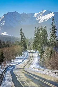 Winding Prints: Cold and snowy black asphalt road leading to Tatra mountains, Poland