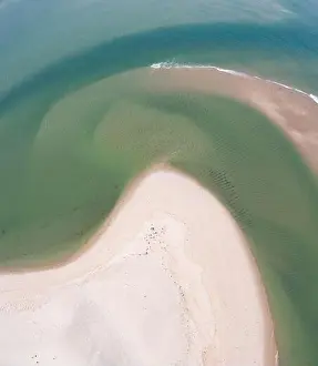 The cold water of the Atlantic Ocean washes onto a beautiful sandy beach on Cape Cod, Massachusetts. This scenic peninsula is a popular vacation area