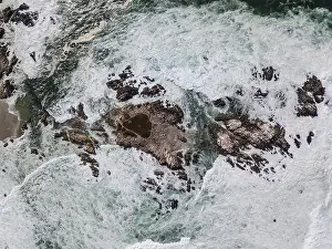 The cold waters of the Pacific Ocean wash against the rocky Northern California coastline in Monterey, just south of San Francisco