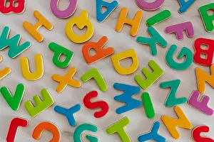 Clipped Prints: colorful mixed letters pile on a marble table, top view