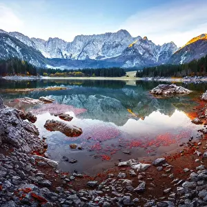 Colorful sunrise on Fusine lake. Picturesque autumn scene with Mangart peak on background. Julian Alps, Udine Province, Italy