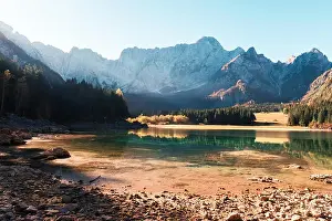Colorful sunrise on Fusine lake. Picturesque autumn scene with Mangart peak on background. Julian Alps, Udine Province, Italy