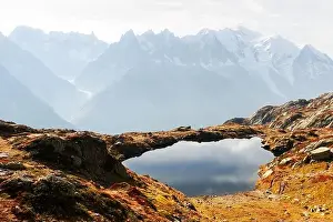 Colourful autumn landscape with Chesery lake (Lac De Cheserys) and snowy Monte Bianco mountains range on background