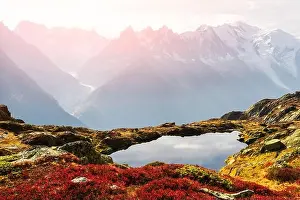 Colourful autumn landscape with Chesery lake (Lac De Cheserys) and snowy Monte Bianco mountains range on background