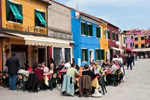 Colourful houses and outdoor restaurant in village of Burano near Venice in Italy