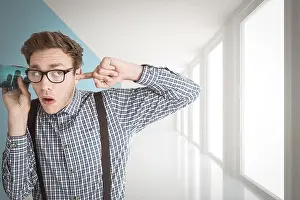 Composite image of geeky businessman eavesdropping with cup