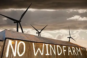 composite of a wind farm and an anti wind farm protest on a barn outside Carlisle, Cumbria, UK