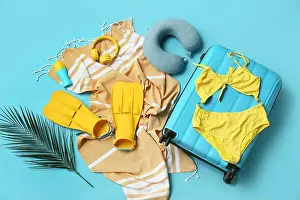 Sunscreen Prints: Composition with suitcase, swimsuit, paddles and beach accessories on blue background