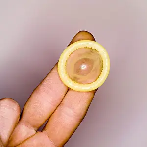 Grownup Prints: Condom on man's hand, elevated view, close-up