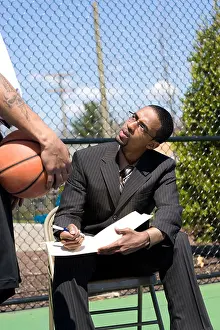 Discussing Prints: A confident coach speaking to one of his players on the basketball team