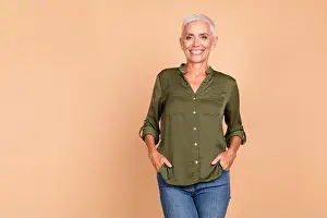 Inspiring Prints: Confident mature woman with a charming smile wearing a stylish khaki shirt posing against a beige background