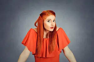 Confusion Prints: Confused young redhead woman looking at you camera