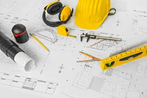 Drafting Prints: Construction plans with yellow helmet and drawing tools on blueprints