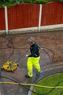 Driveway Prints: Contractors cleaning domestic block paved driveway with high pressure water