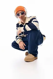 Poses Prints: A cool teenager shows off their unique style in a striped polo and bright orange hat