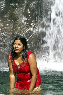 Pool Prints: Corpulent young indian woman bathing outdoors under waterfall, dressed in red singlet