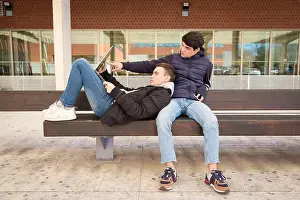 25 30 Years Prints: couple two gay university students together on a bench using laptop computer
