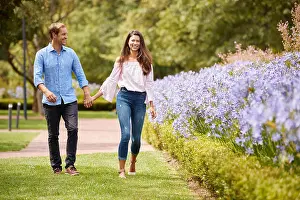 Holding Hands Prints: Couple Holding Hands On Romantic Walk In Park Together