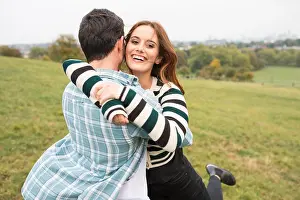 Young Couple Prints: Couple hugging in field