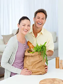 Couch Prints: Couple laughing standing in the kitchen with shopping bags