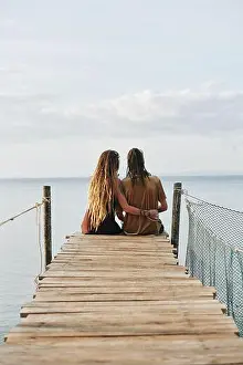 Recreational Pursuit Prints: Couple in love sitting on wooden pier and enjoying beautiful seascape, view from the back