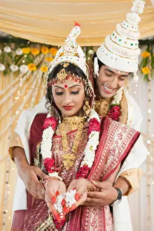 Young Couple Prints: Couple performing Anjali ceremony in Bengali wedding