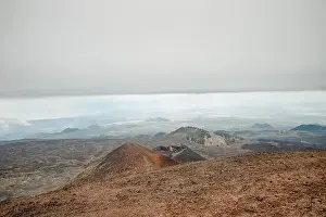 Top of crater Mount Etna volcano, frozen cold lava smokes, thick clouds