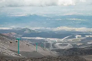 Earthquake Prints: Top of crater Mount Etna volcano, frozen cold lava smokes, thick clouds